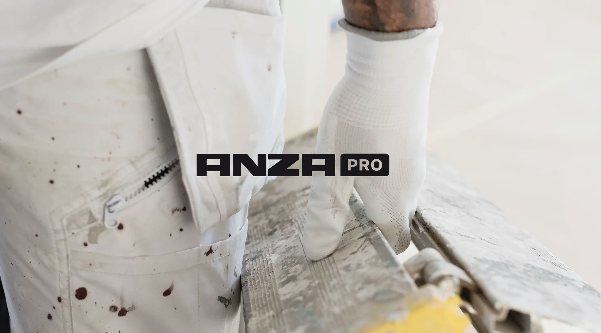 Anza Pro's logga över en bild på smutsiga målarbyxor och en hand som håller en smutsig stege