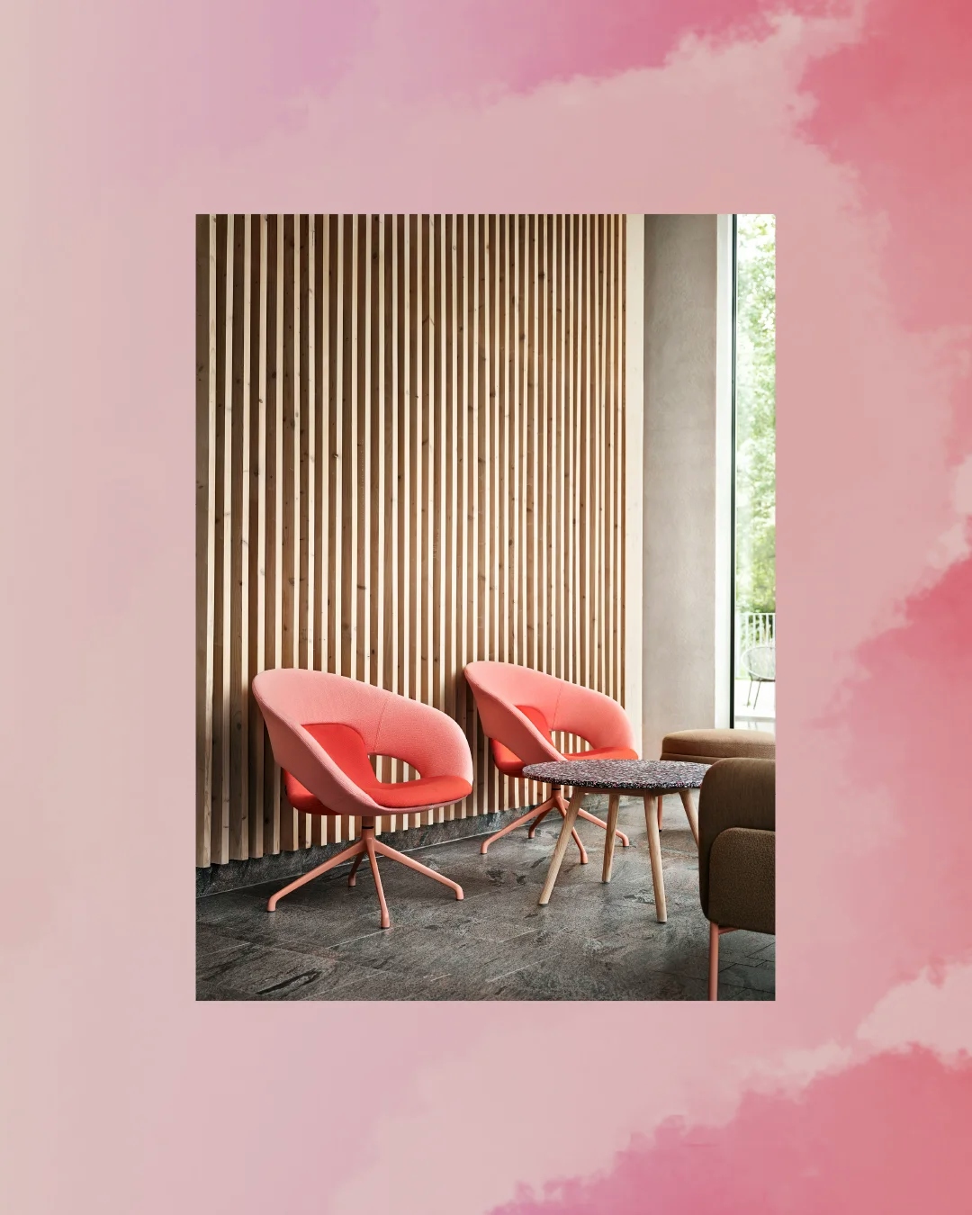 Två ljusrosa mjuka stolar framför en vägg gjord av lodräta mörka plankor