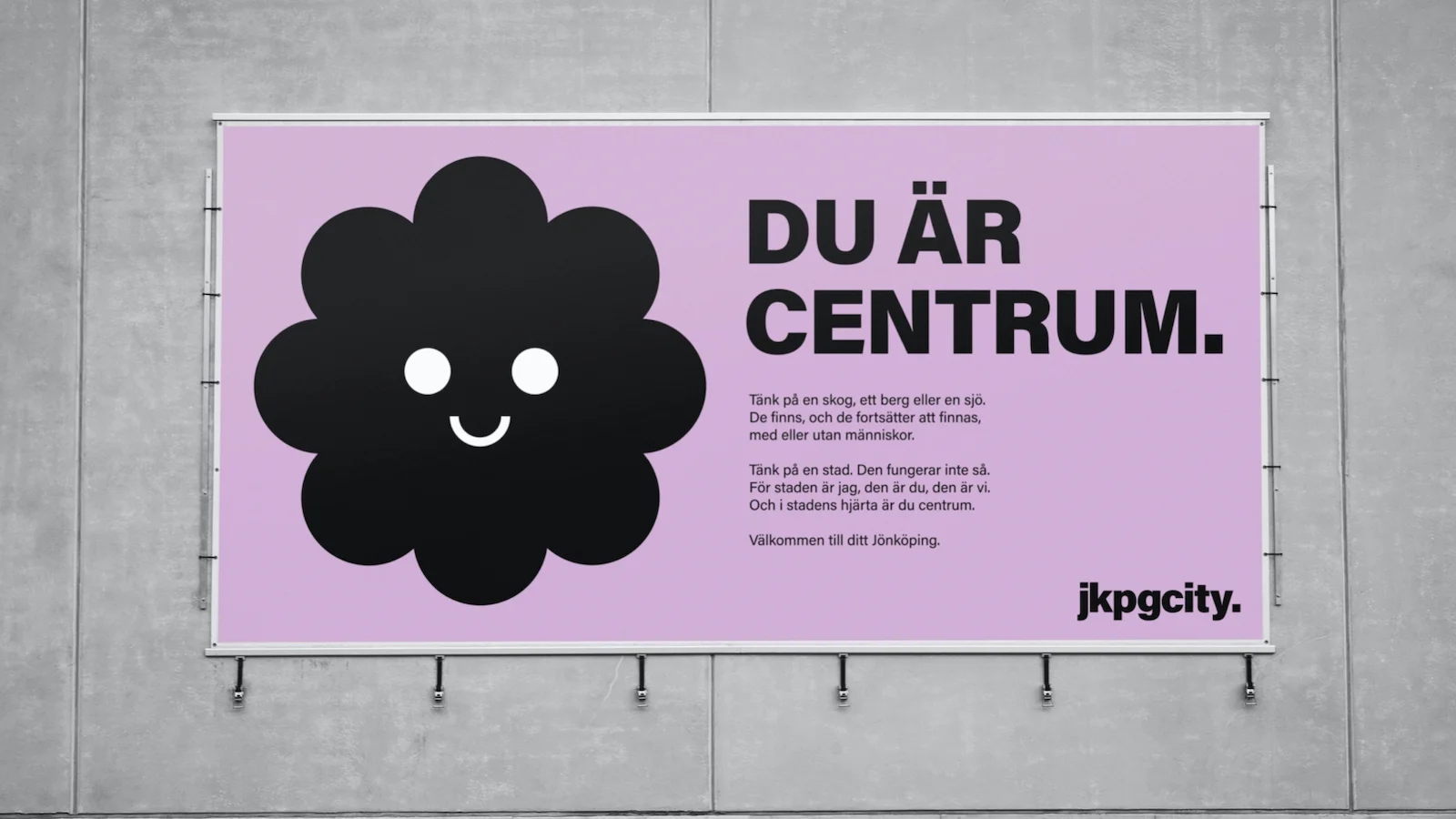 reklamskylt med logotyp, rubrik "Du är i centrum" och text.